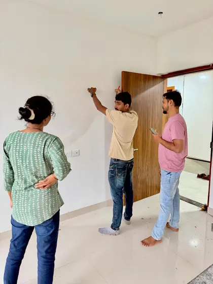 On-site with clients, measuring and marking the wall for furniture placement. Precision from the start is essential.