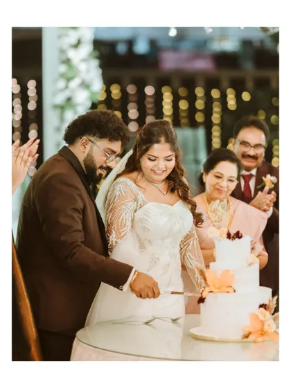 The cake-cutting ceremony, a sweet moment shared with family. This photo captures the tradition and joy of this classic wedding reception event.