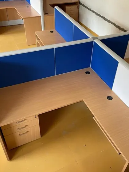 An overhead view of a four-person workstation cluster. These cubicles feature low partitions with fabric panels that offer some privacy and acoustic absorption.