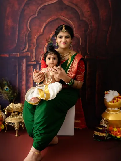 A mother and her baby dressed as Yashoda and Krishna. This traditional setup with an ornate arch backdrop is one of my popular options for Janmashtami.