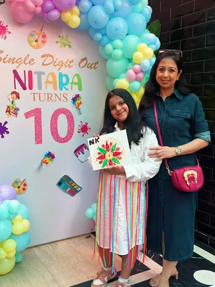Celebrating a special 10th birthday. The birthday girl proudly displays the beautiful mandala canvas she created, a perfect memory from her unique art-themed party.