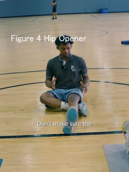 A coach demonstrates the setup for the figure four hip opener, emphasizing correct posture.