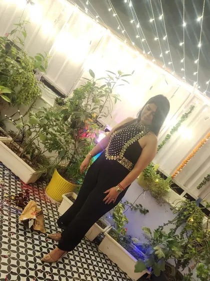 A high-angle shot of the client in her black jumpsuit, showing off the beautiful embellished neckline.