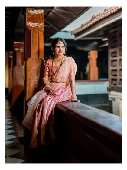 An elegant solo portrait of the bride-to-be on her engagement day, seated on a veranda, looking thoughtful and serene.