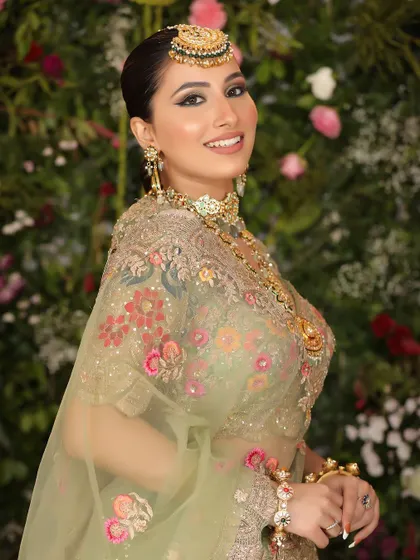 A joyful bridal portrait against a floral backdrop. The model's smile and the soft lighting create a warm and inviting image, perfect for a wedding campaign.