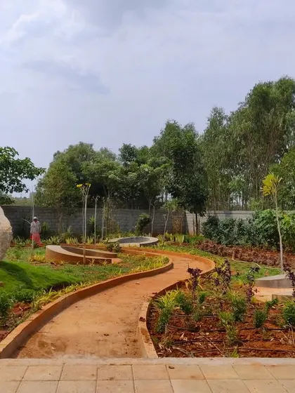 A work-in-progress view of the winding pathways and curved seating areas at 'The Sanctuary', showing the foundational forms of the landscape design.