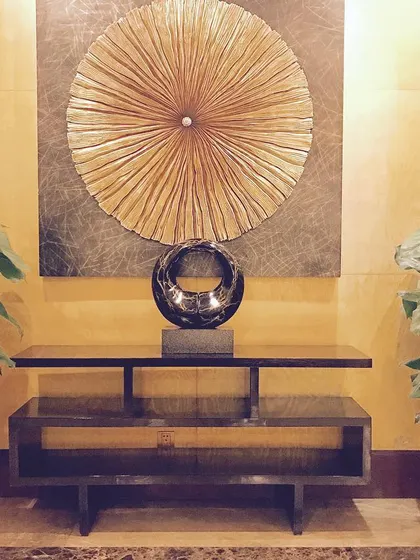 This gorgeous console table was for a happy client, placed to create a perfect, complete look in their entryway. The dark wood finish, metallic art piece, and surrounding plants come together to create a welcoming ambiance.