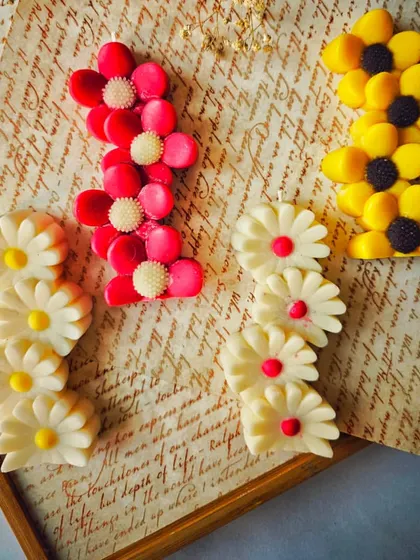 Another view of the vibrant Floral Symphony candles. Their unique stacked-flower shape makes them a fun and modern decorative candle for any occasion.