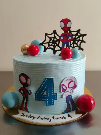 A Spidey and his amazing friends themed cake for a 4th birthday. This blue cake is decorated with Spider-Man, Ghost-Spider, and Spin.