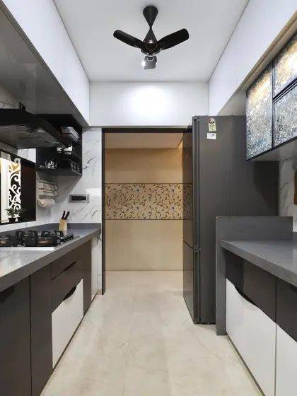 A view down the length of the galley kitchen, showing the efficient use of space. The layout provides a clear workflow from the refrigerator to the cooking area, with continuous countertop space.