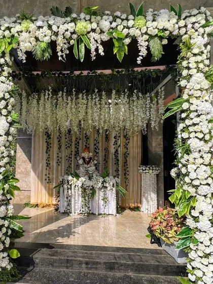 We believe a beautiful beginning sets the tone for the entire event. This grand entrance arch, crafted with a dense arrangement of white carnations, roses, and hanging wisteria, provides an elegant and memorable welcome for your guests.