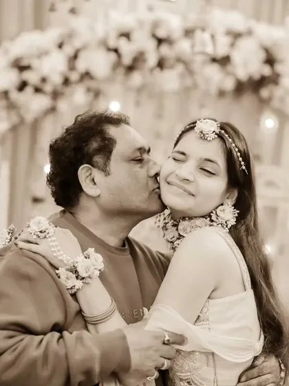 A father's affection for his daughter. A gentle kiss on her cheek during the Haldi ceremony, this photo is a beautiful testament to their bond.