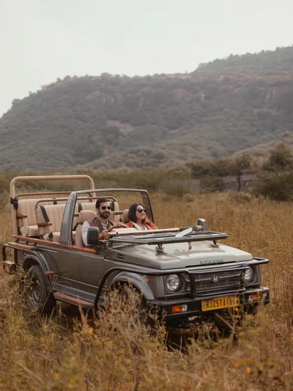 An adventurous pre-wedding shoot in Ranthambore, with the couple enjoying a private moment in a safari jeep amidst the wild, rustic landscape.