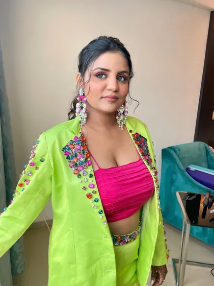 She is just so fine. A bold and colorful look for the sister of the bride, featuring a neon green pantsuit and a pop of pink on the eyes.