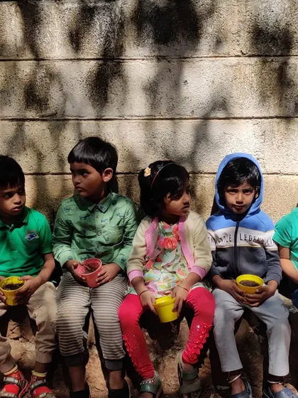 Children with their pots, having just planted seeds. This activity is the beginning of a long-term observation project as they will water their plants and watch them grow over time.