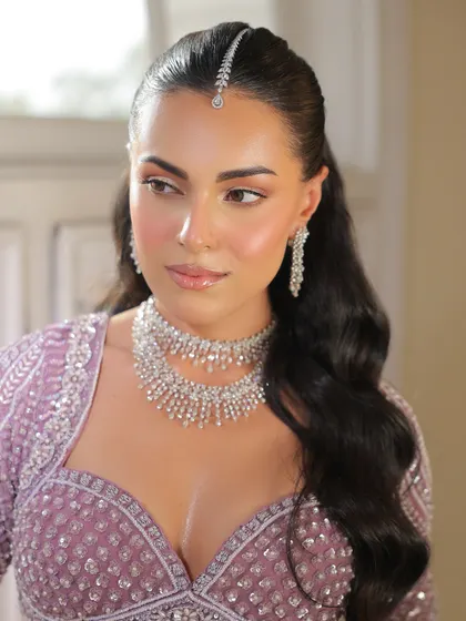 A close-up on the bride's soft, glowing makeup and the delicate diamond jewelry that completes this summer bridal look.