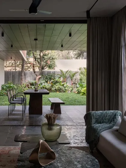 The living room at Pràna, a space designed for family connection. The comfortable sofas and open layout invite conversation and relaxation, with the lush garden always in sight.