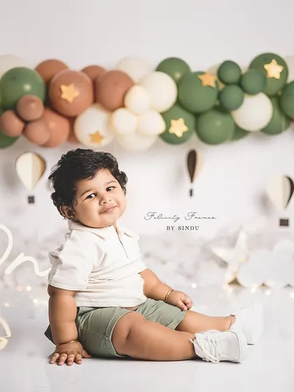 A calm and sweet portrait from a hot air balloon themed first birthday. The earthy tones of the balloons create a gentle and soothing atmosphere.