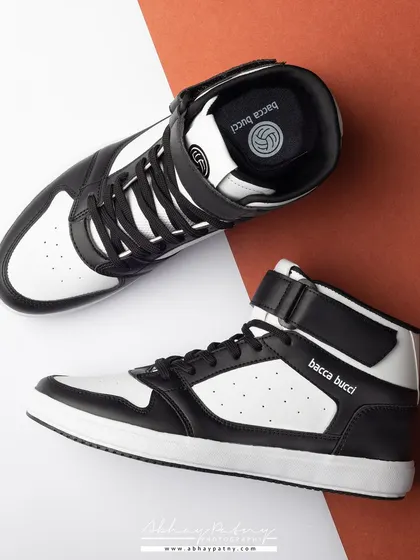 A top-down flat lay of high-top sneakers. This perspective provides a clear view of the shoe's design and branding, and the two-tone background adds a graphic, modern element.