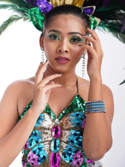 A close-up of the carnival costume, showing the detailed sequin work and bold, colorful makeup.