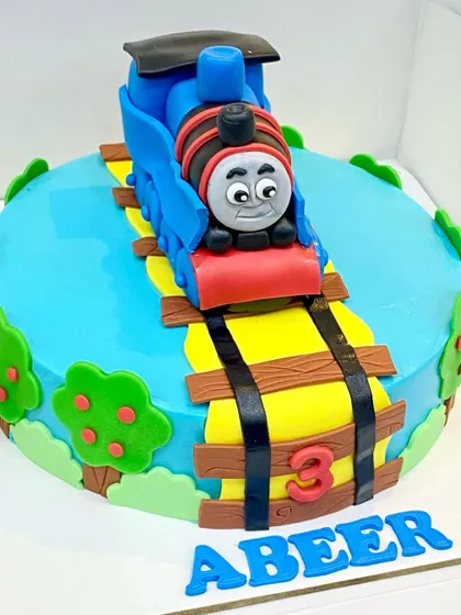 All aboard for a 3rd birthday! This Thomas the Tank Engine cake features a fully handcrafted and edible Thomas on a track, surrounded by fondant trees and scenery.