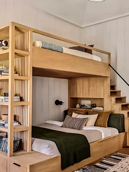 This custom bunk bed is a complete bedroom solution, with a built-in staircase that has storage drawers, and an integrated full-wall bookshelf. The natural wood finish gives it a timeless, sturdy feel.