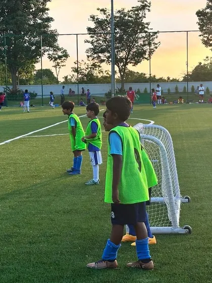 Focus and determination on display. A young player wearing a green bib stands ready for the next play, learning the importance of positioning and awareness during a training game.