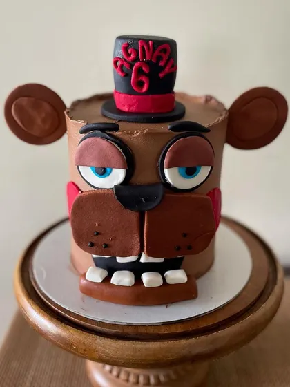 A close-up view of the character's face, showing the fondant eyes and hat.
