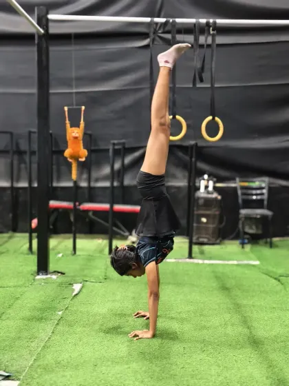 A demonstration of a freestanding handstand, a fundamental skill in calisthenics that requires balance, control, and strength.