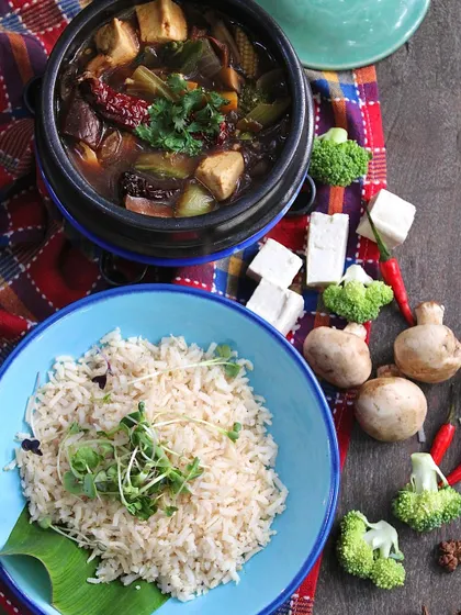 The Sichuan Claypot, presented with a side of fluffy brown rice. This dish is a perfect example of how we create bold, international flavors using only whole, plant-based ingredients.
