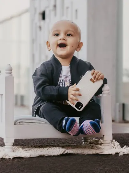 An expressive shot of a baby boy with a big, open-mouthed smile during his pre-birthday photoshoot.