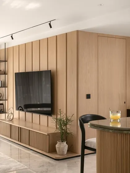 A view of the TV unit in the Noir Blanc House, featuring warm Oakwood veneer partitions and a hidden door, demonstrating how I integrate storage and function seamlessly into a clean design.
