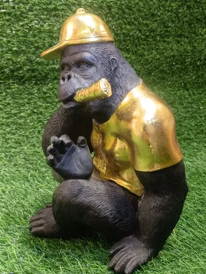 This cool chimpanzee showpiece, wearing a golden t-shirt and cap while smoking a cigar, adds a humorous and edgy vibe to your decor.