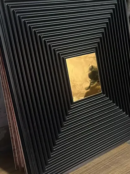 A dramatic black PVC panel with a grooved texture and a central gold mirror, perfect for creating a bold, high-contrast feature.