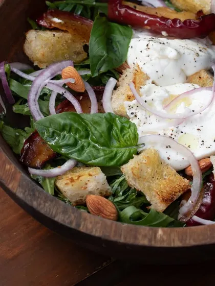 Our Panzanella salad, a classic Italian bread salad. We use our own sourdough, toasted to perfection, and toss it with roasted apples, almonds, and fresh burrata.