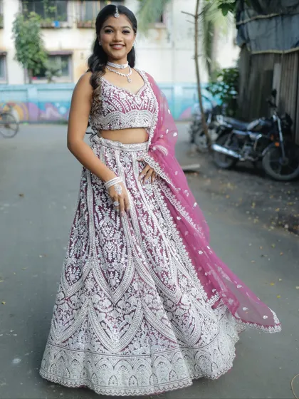 A happy and smiling full-length shot of the purple and silver lehenga, perfect for a wedding guest.