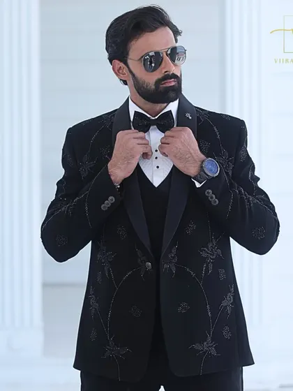 Adjusting the bow tie on our custom black tuxedo. Every element, from the lapel to the buttons, is chosen to create a cohesive and polished final look.