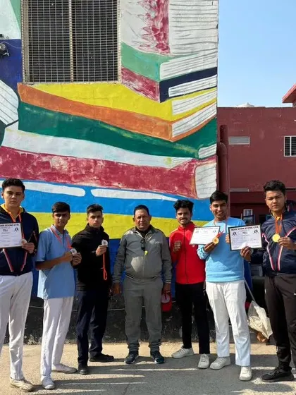 Posing with medals in front of the Apex Public School mural. We are proud to represent our partner school.