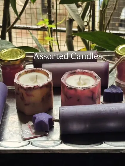 A beautiful assortment of our handmade candles on a silver tray. This collection includes various pillar candles, jar candles, and small heart-shaped melts, showcasing the variety I offer.