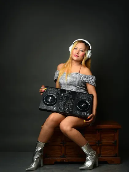 A creative pose with the DJ console. This is more than a headshot; it's a branding image that communicates her profession and passion instantly.