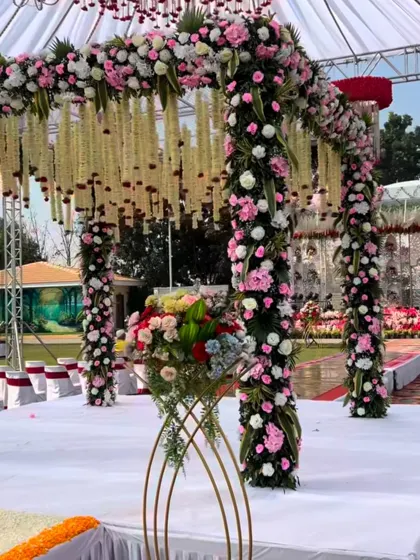 A beautiful outdoor mandap decorated with pillars of pink and white flowers and a ceiling of hanging jasmine strings (mogra).
