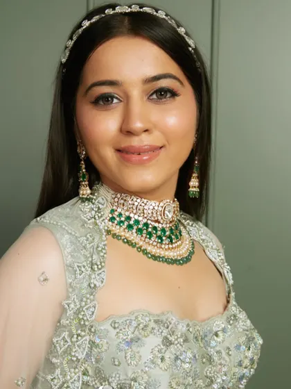 A portrait of the same look, highlighting the flawless base and the elegant jewelry.