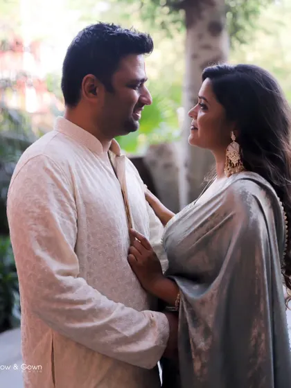 A sweet, candid moment from a Roka ceremony. The couple is looking at each other with love and affection, captured in beautiful, natural light.