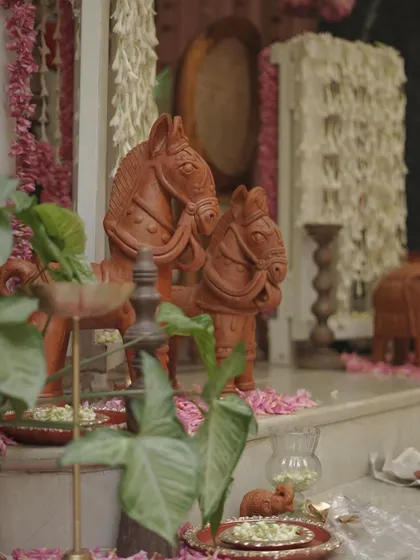 Terracotta horse figurines placed as part of the decor. These traditional Indian craft items add an earthy, rustic charm to the floral and brass elements.