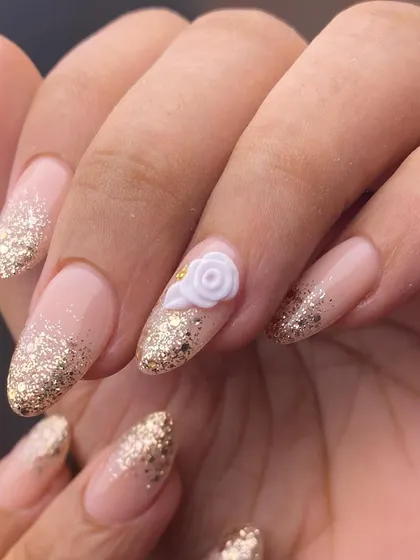 Simple elegance for any special occasion. This design features a soft glitter gradient on almond-shaped extensions with a single, delicate 3D white rose as a sophisticated accent.