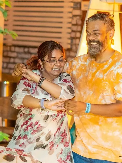 A joyful, carefree moment between two dancers. The tie-dye and floral prints add to the vibrant feel of the night.