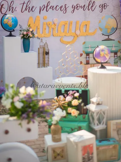 A close-up of the "Oh, the places you'll go!" decor, showing vintage globes, travel-themed props, and beautiful floral arrangements that add to the adventurous and whimsical feel.