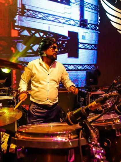 Our drummer in his element, surrounded by his kit. The live drums provide the powerful, driving beat that is the foundation of our rock-solid rhythm section.