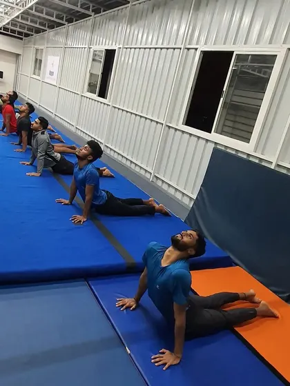 A different angle of our adult class holding the cobra pose, showing a commitment to improving flexibility and strength together as a group.