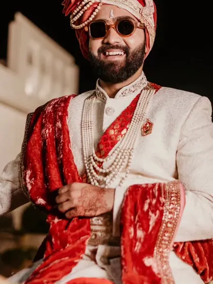 The groom on his horse, smiling and ready for his baraat. This is a classic, joyful shot of the Indian groom.